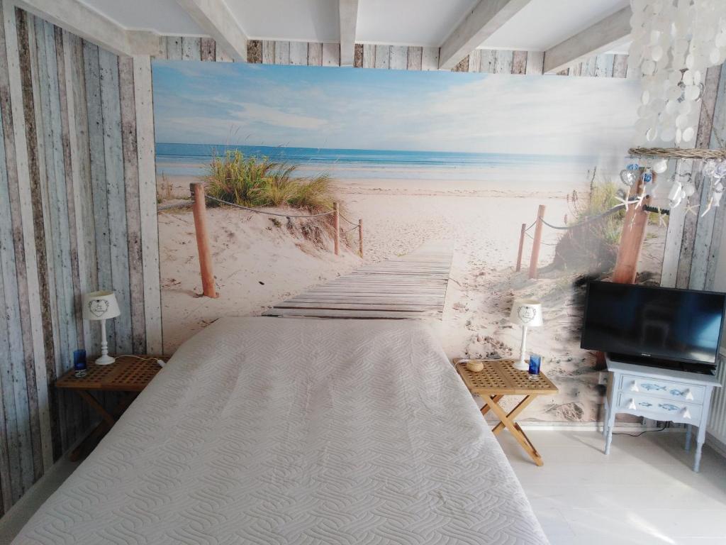 un letto in una stanza con un murale sulla spiaggia di Tante Cher à la Mer - Zeeland a Biggekerke
