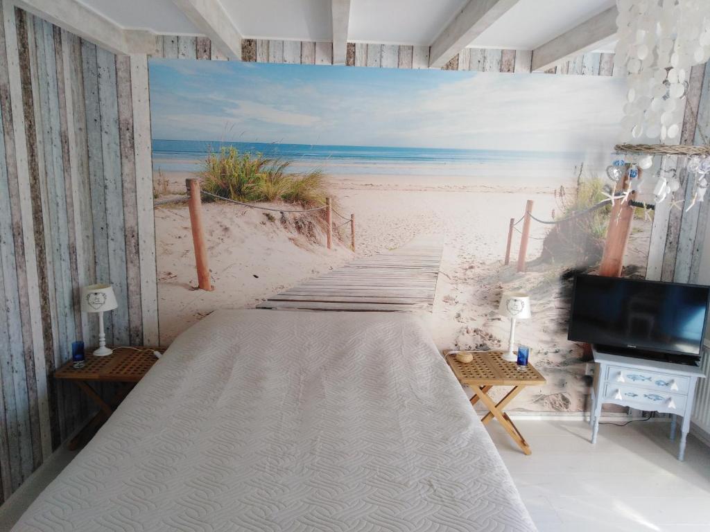 a bed in a room with a beach mural at Tante Cher à la Mer - Zeeland in Biggekerke