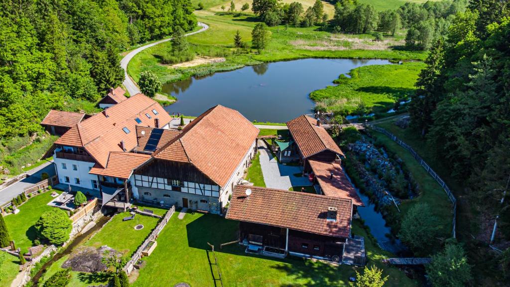 una vista aérea de una gran casa con un lago en Naturidyll Kollnbergmühle, en Fürstenstein