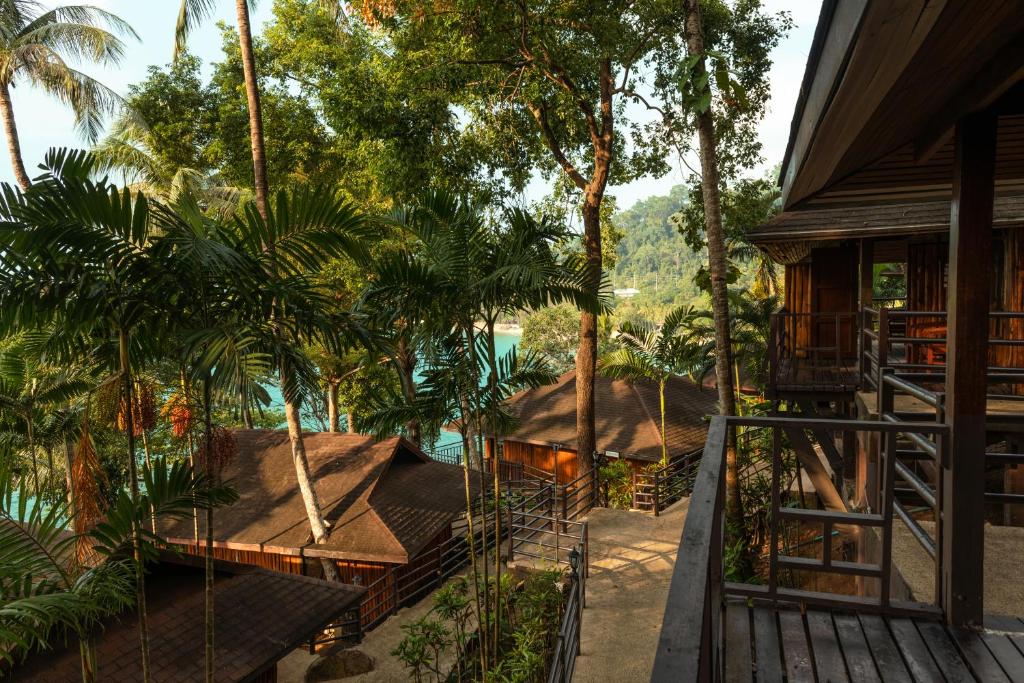 Elle offre une vue sur une maison avec des arbres et une terrasse couverte. dans l'établissement Baan Krating Khao Lak Resort - SHA plus, à Khao Lak