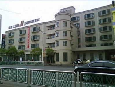 un edificio con un coche aparcado delante de él en Jinjiang Inn - Huaian Wanda Plaza East Jiankang Road en Huai'an