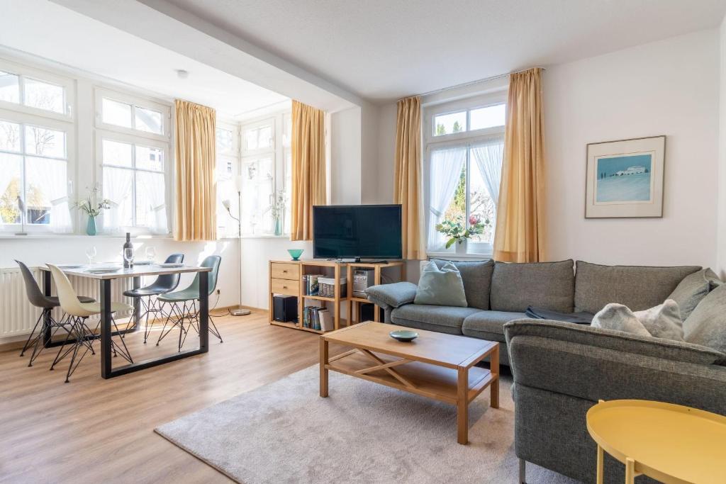 ein Wohnzimmer mit einem Sofa und einem Tisch in der Unterkunft Villa Eden Binz Typ 5 (Apt.14) in Binz