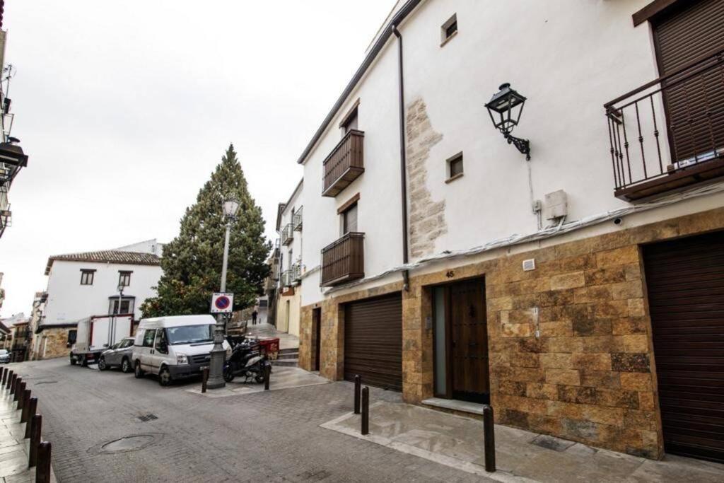 a building with a car parked next to a street at Vivienda turística Lagarto de Jaén in Jaén