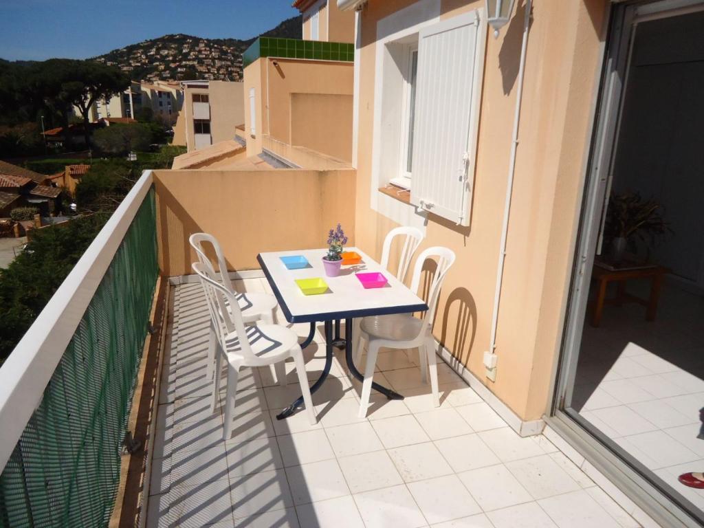 uma varanda com uma mesa e cadeiras em Appartement climatisé avec grande terrasse plein sud em Cavalaire-sur-Mer