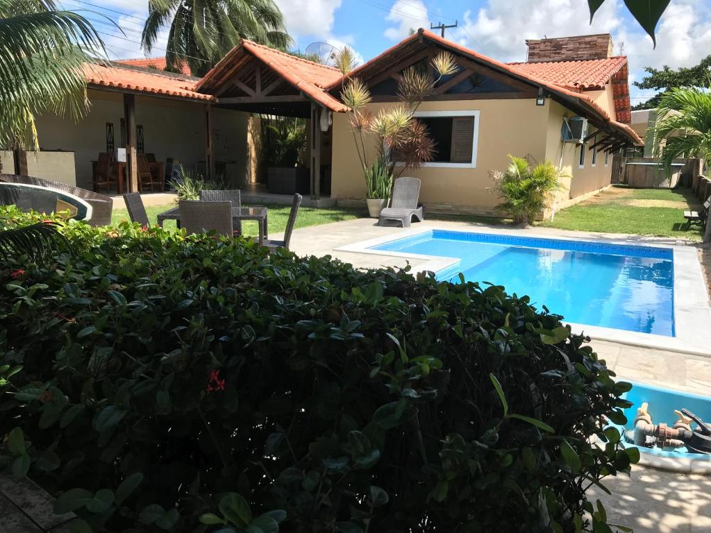 una villa con piscina frente a una casa en Casa Praia dos Carneiros, en Praia dos Carneiros