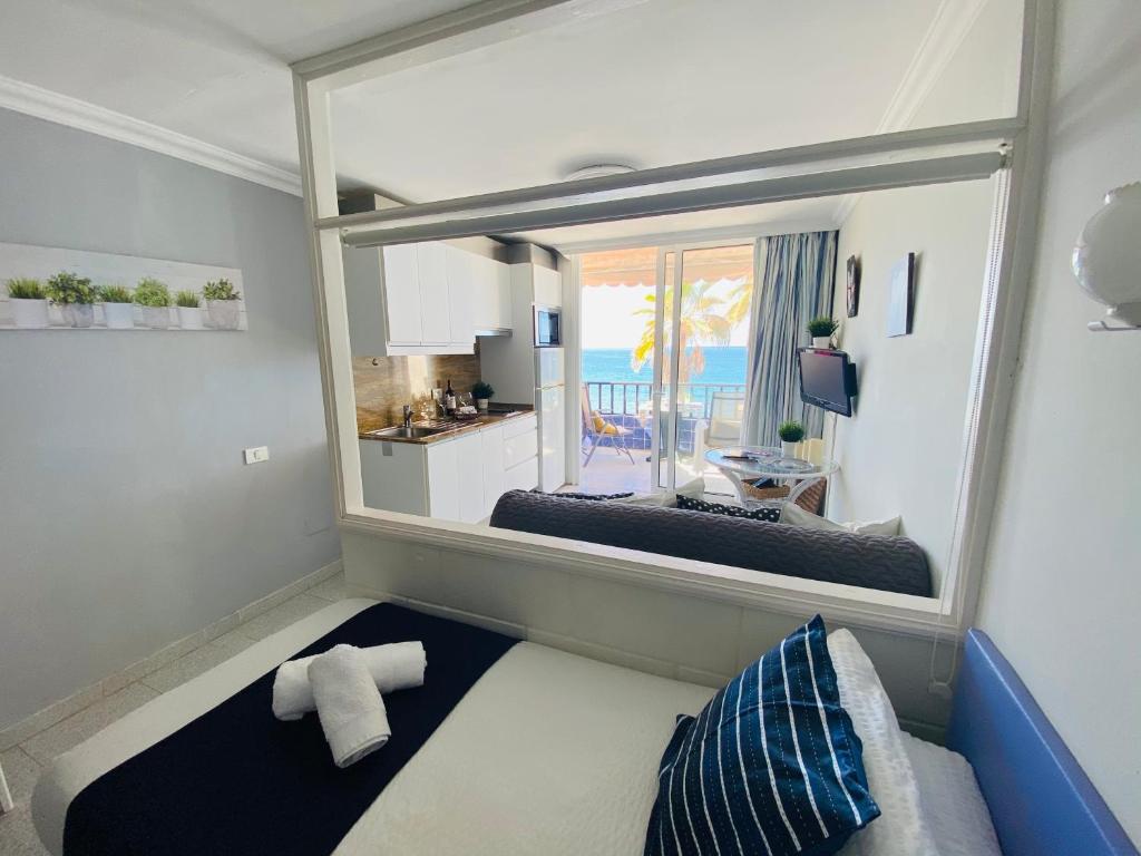 a room with a large mirror and a room with a couch at Beach Apartment 3 in Patalavaca