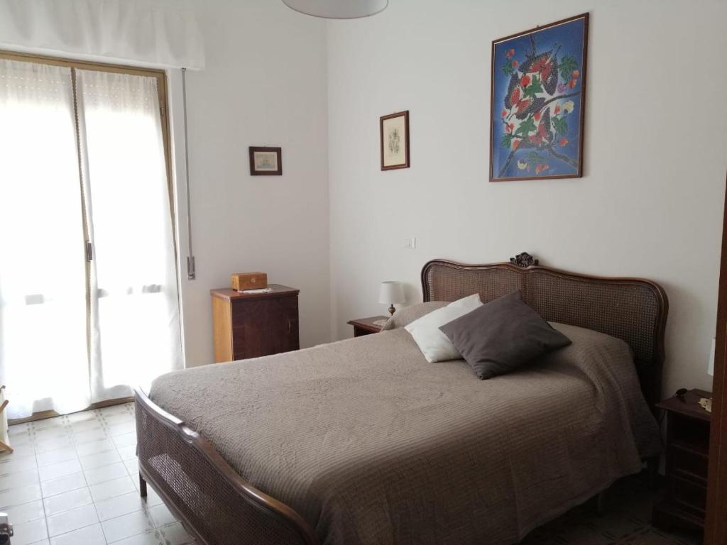 a bedroom with a bed and a window at La casa di GB in Pieve di Teco