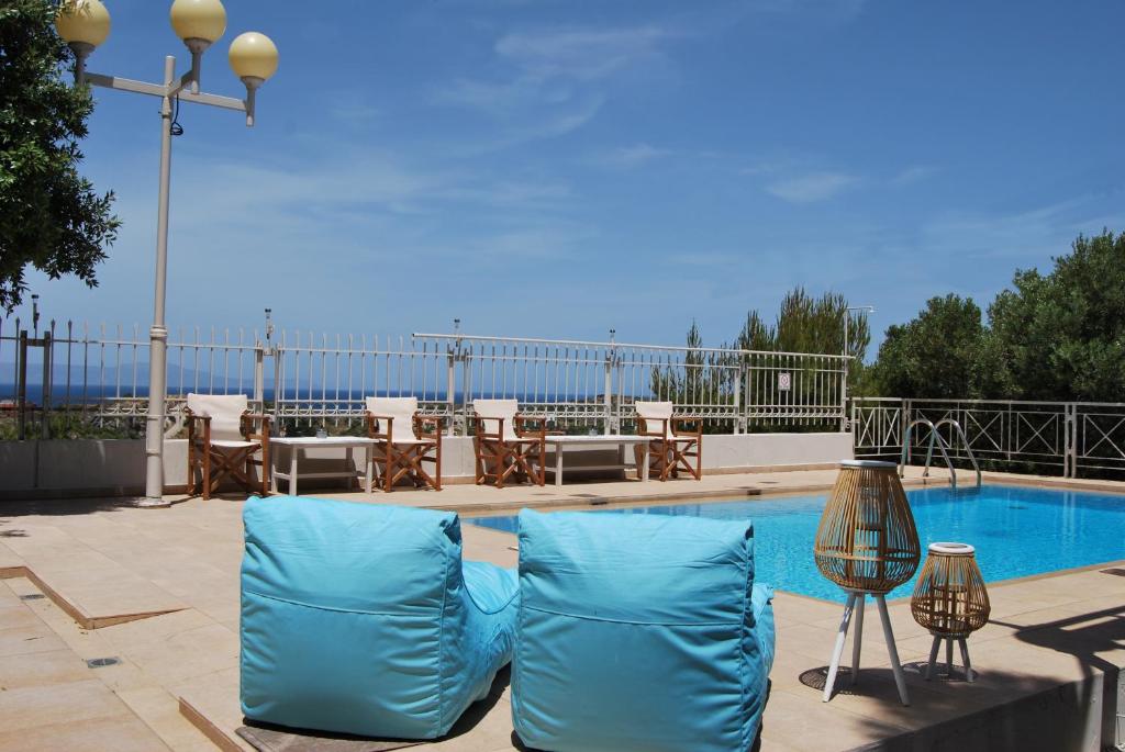 a pair of blue chairs sitting next to a swimming pool at Chrysiida Suites in Tersanas