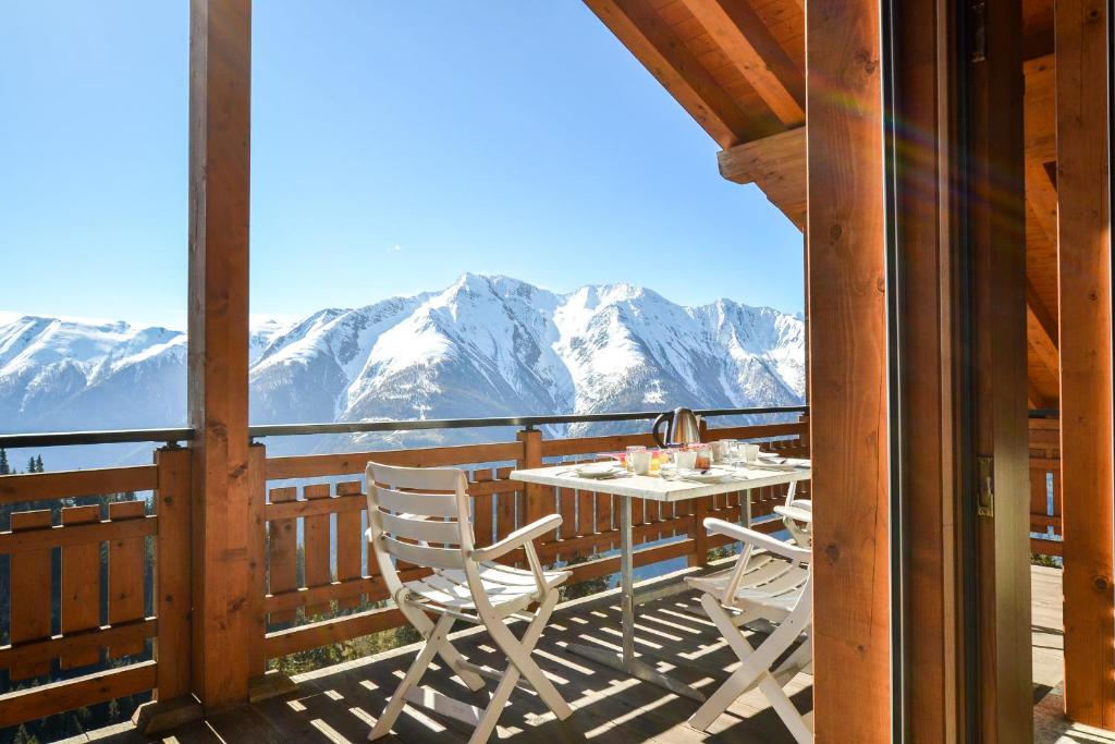 Casa Arturo Penthouse في ريدرالب: طاولة وكراسي على شرفة مع جبال مغطاة بالثلج