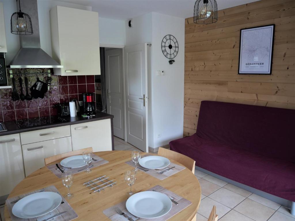 a kitchen with a table with plates and glasses on it at La perle du Grand Haut in Gérardmer