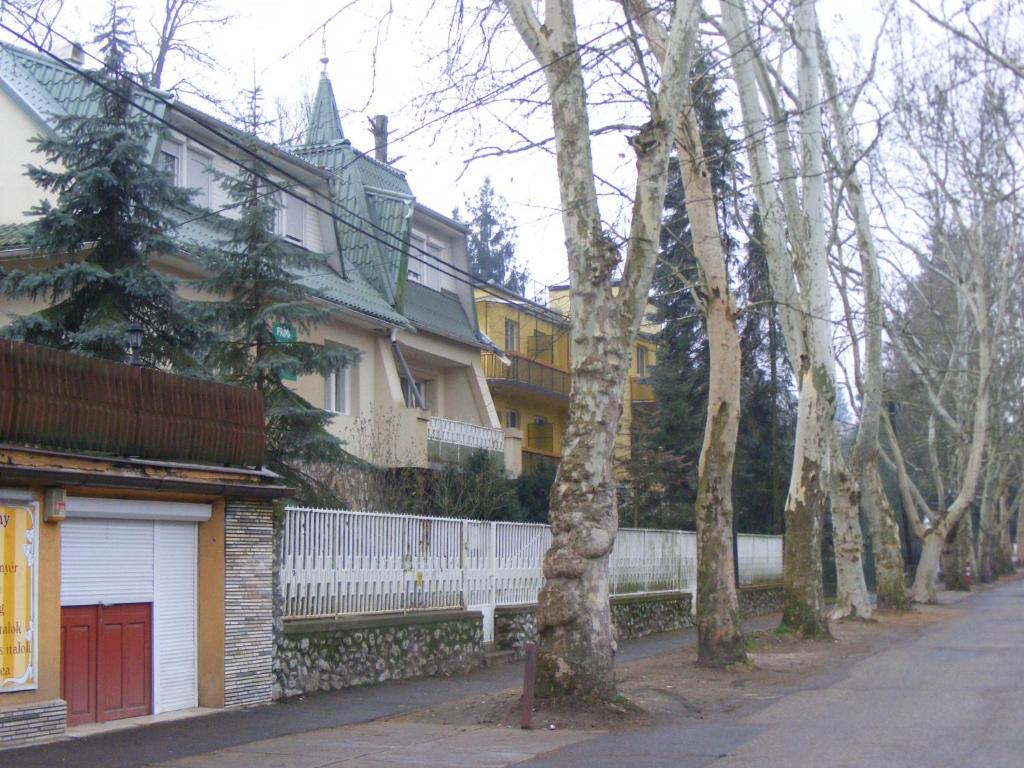 une rangée de maisons avec des arbres et une clôture dans l'établissement Prima Pihenő, à Miskolctapolca