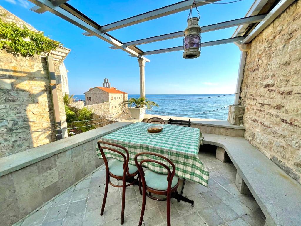 a table and chairs on a balcony with a view of the ocean at Budva Old Town Beach House in Budva