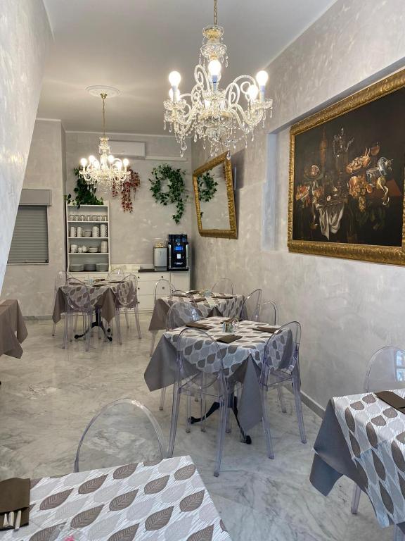 jadalnia ze stołami i obrazem na ścianie w obiekcie La Serenissima Hotel w mieście Palermo