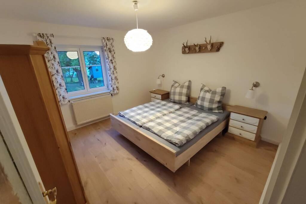 um quarto com uma cama, uma mesa e uma janela em Ferienwohnung Ramona - idyllisch und charmant em Kirchdorf im Wald