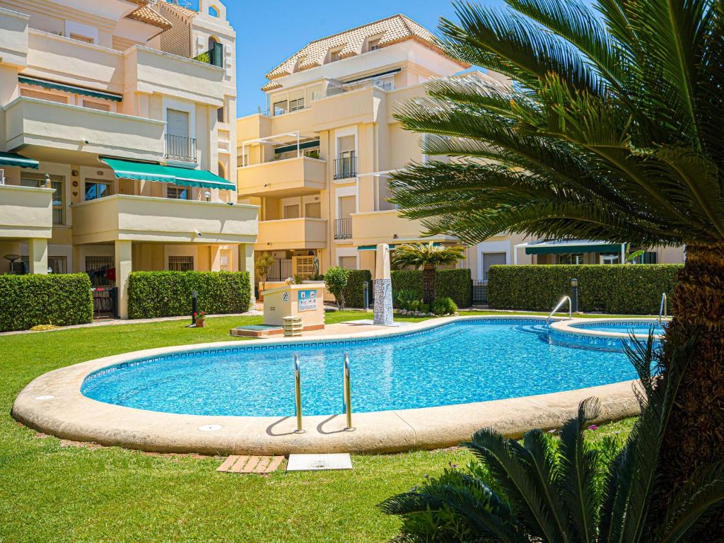 een zwembad in een tuin naast een gebouw bij Apartment with pool in Urb Medina del Sol in Denia