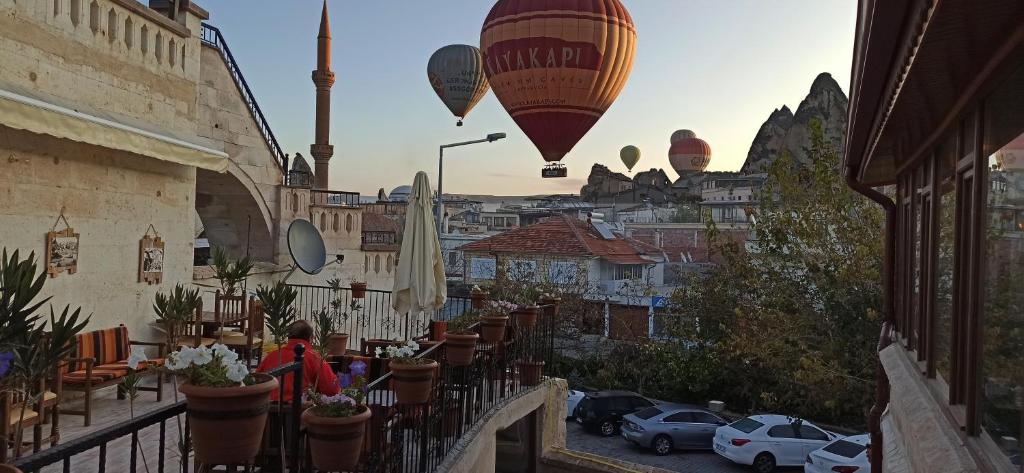 a person walking down a balcony with hot air balloons at Adelya Cave Hotel in Goreme