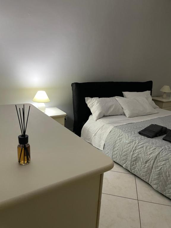 um quarto com uma cama e uma mesa com um candeeiro em IL QUADRIFOGLIO intero appartamento centro città em Villa San Giovanni