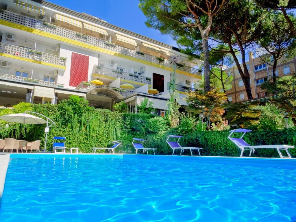 a swimming pool in front of a building at Hotel Abbazia in Lignano Sabbiadoro