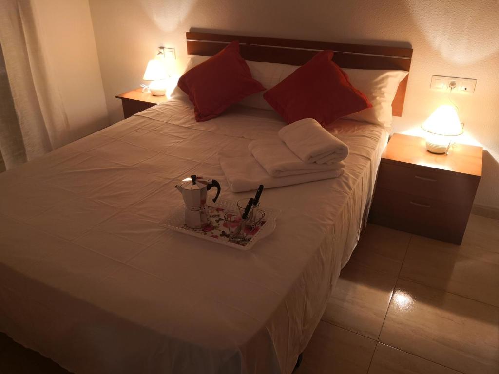 ein Bett mit zwei Handtüchern und einer Kerze drauf in der Unterkunft Centro Roquetas 5 minutos de la playa en Coche Garaje solo si esta disponible in Roquetas de Mar