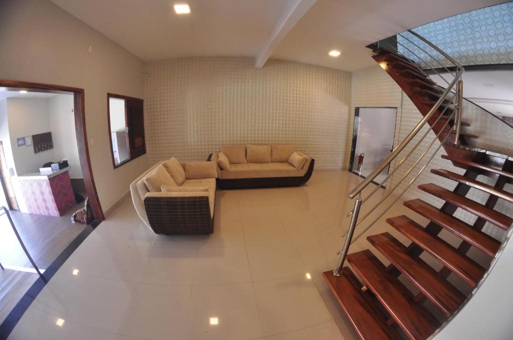 a living room with a couch and a staircase at Pousada Receptur in Piranhas