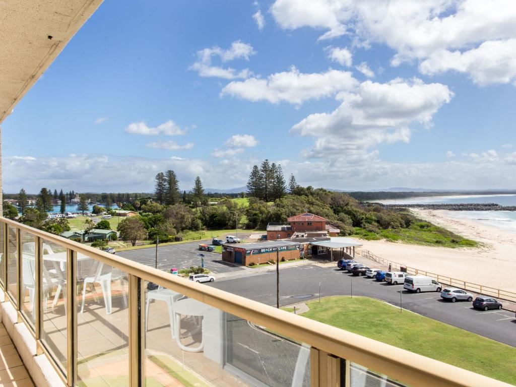 a balcony with a view of the beach and a parking lot at Ebbtide 22 in Forster