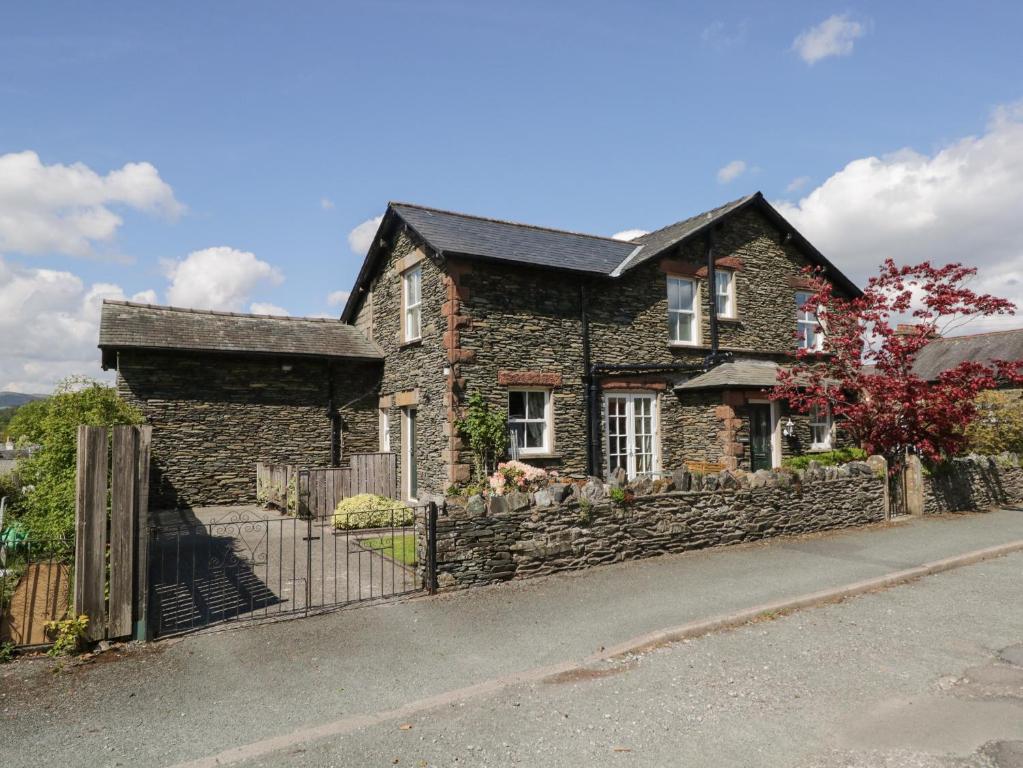 a stone house with a fence in front of it at Silverthwaite in Windermere