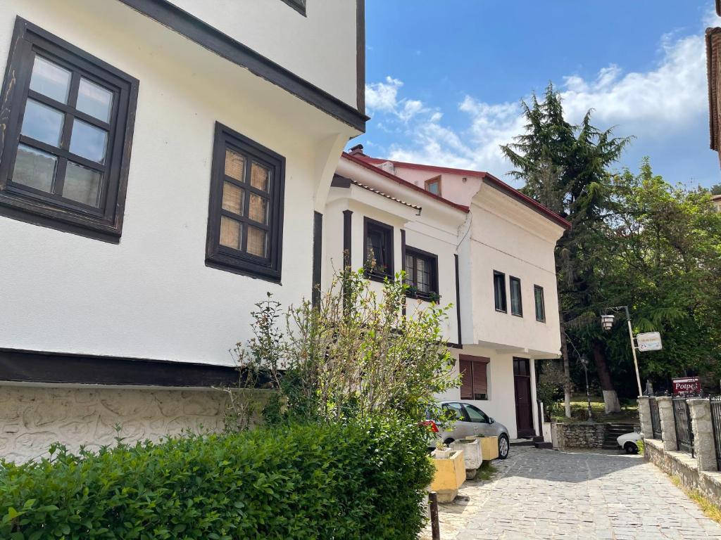 une maison blanche avec une voiture garée dans une allée dans l'établissement Apartment Boevi, à Ohrid