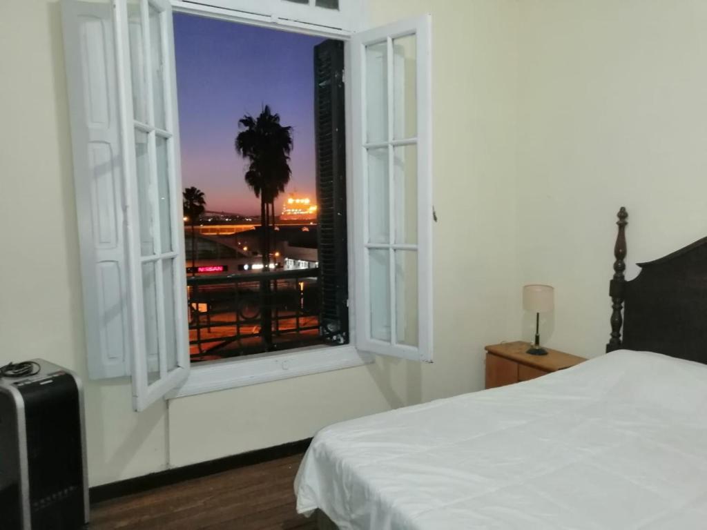 Schlafzimmer mit einem Fenster mit Stadtblick in der Unterkunft Apartamento en Edificio Palacio Colón in Montevideo