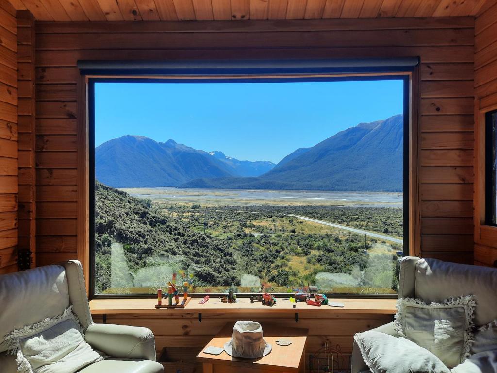 a large window in a room with a view of the mountains at Arthur's Pass Ecolodge in Cass