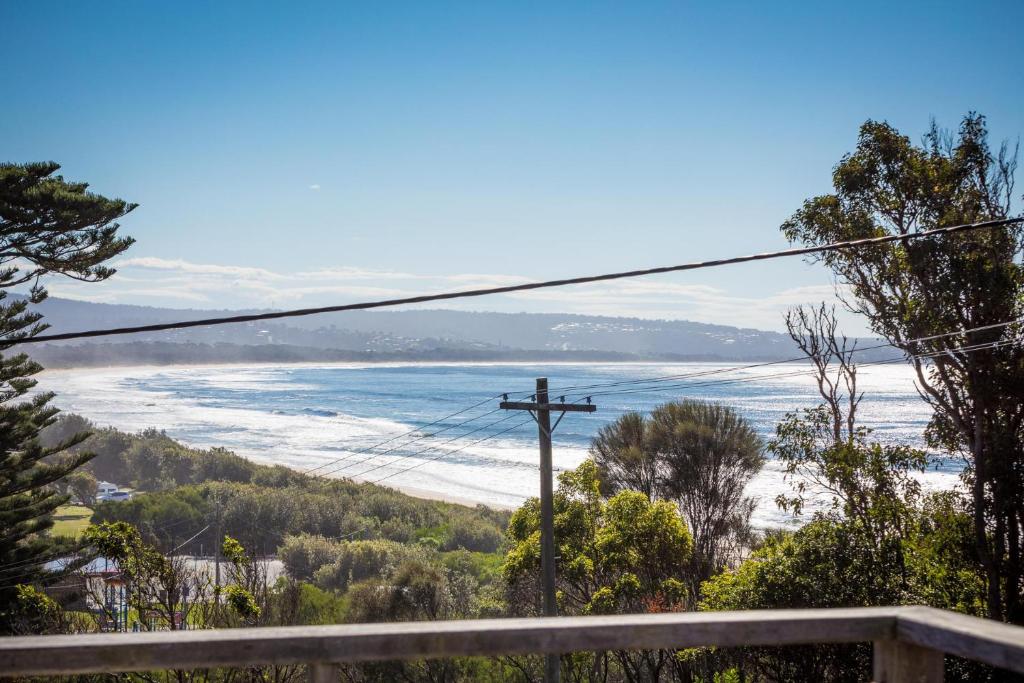 a view of a beach with a wooden pole at Surfside in Pambula Beach