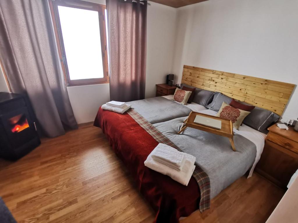 a bedroom with a large bed and a fireplace at PRECIOSO LOSFT FRENTE A PISTAS GRANVALIRA, SOLDEU in Bordes d´Envalira