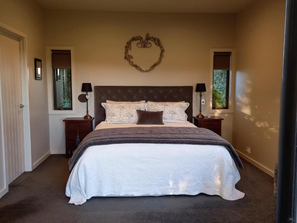 1 dormitorio con 1 cama grande y espejo de aumento en la pared en Appleyard, en Kinloch