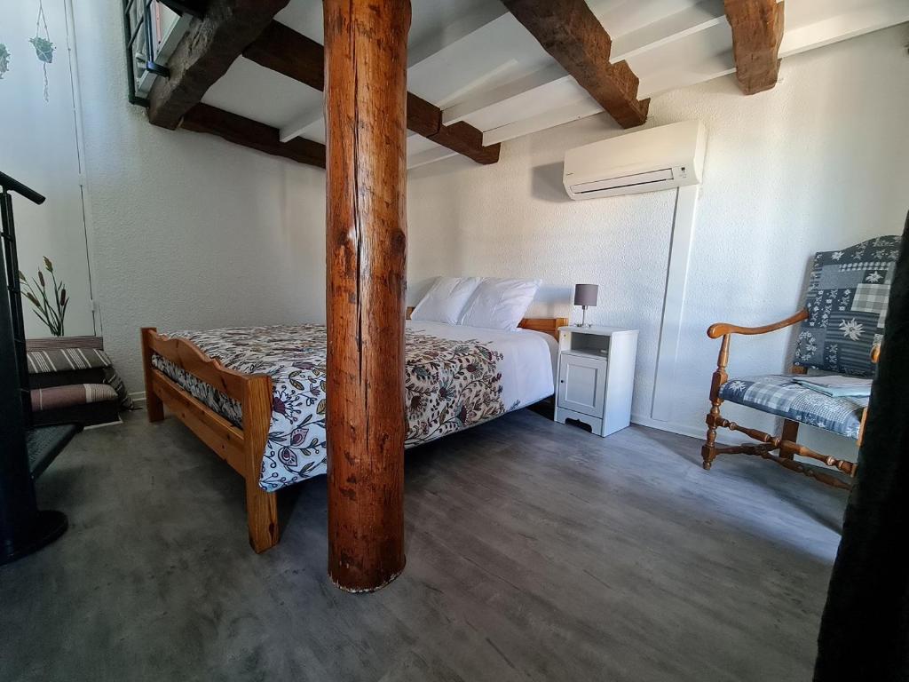 - une chambre avec un lit doté d'un poteau en bois dans l'établissement Le 44 avec balcon vue mer, au Grau-du-Roi