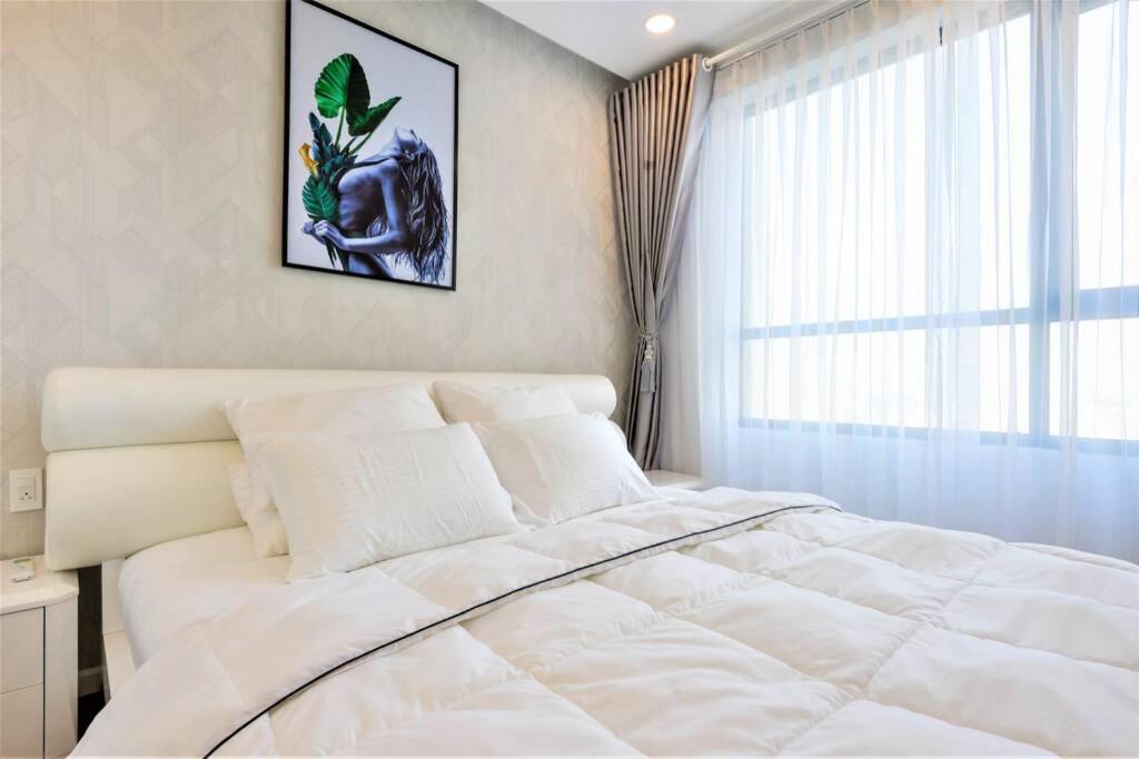 a white bed in a bedroom with a window at GoldView Apartment - District 4 in Ho Chi Minh City