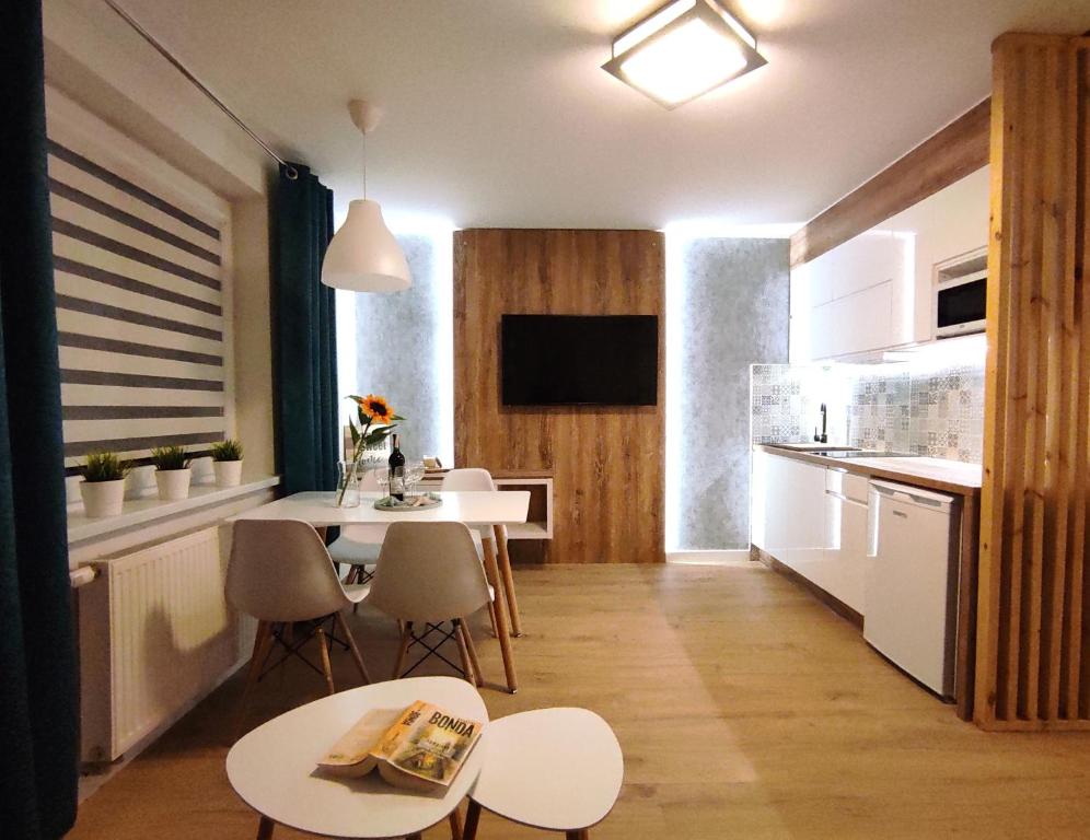 a kitchen and dining room with a table and chairs at LAGO Apartamenty i pokoje in Łeba