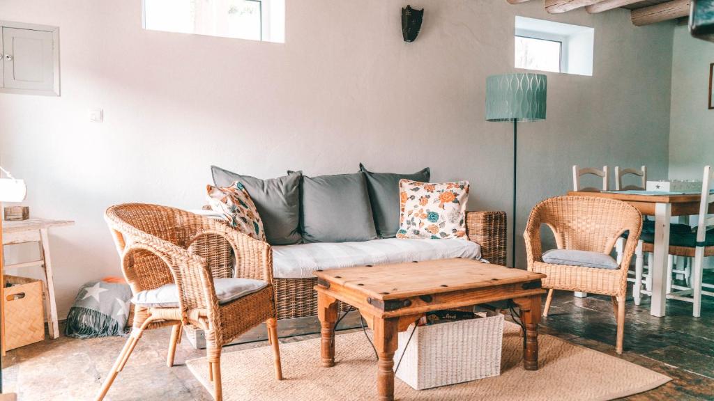 a living room with a couch and chairs and a table at Casa Bordeira in Bordeira