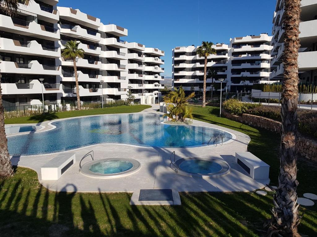 een leeg zwembad voor een groot appartementencomplex bij APARTAMENT GAUDI in Arenales del Sol