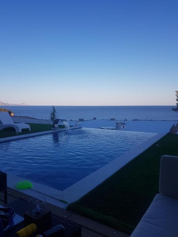 a swimming pool with the ocean in the background at Ocean Island Villa in Achlia