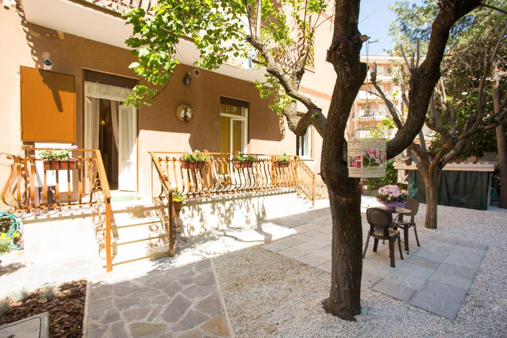 een huis met een boom en een tafel en stoelen bij Casa Lollobrigida in Ciampino