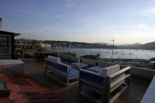 a deck with two chairs and a view of the water at Pensión Iturriza in Donostia-San Sebastián