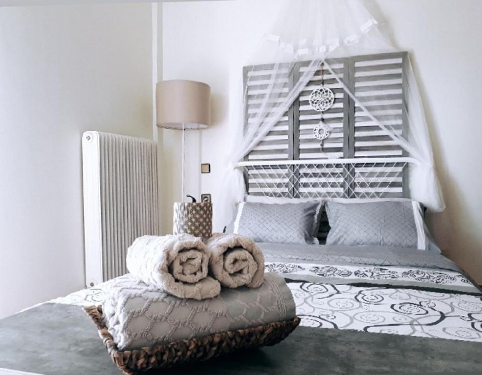 een slaapkamer met een bed met twee handdoeken op een poef bij Urban Yoga House Hostel & Retreat in Ioannina