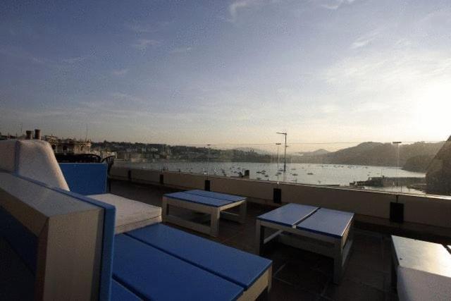 a balcony with benches and a view of the water at Pensión Iturriza in San Sebastián