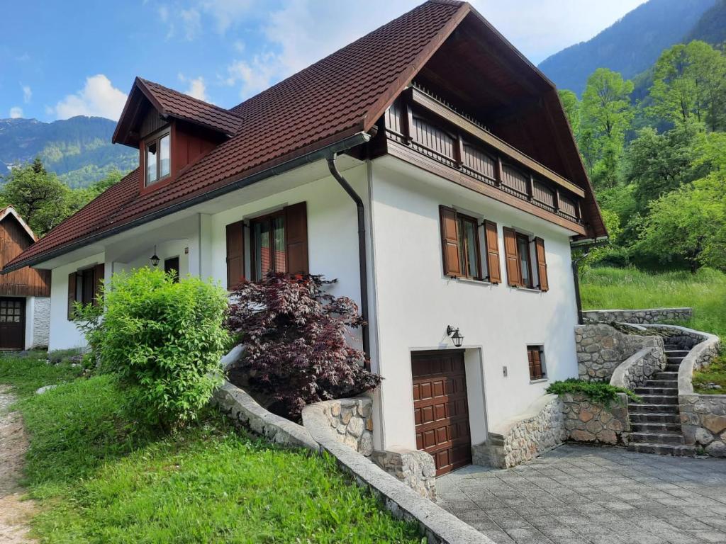 une petite maison blanche avec un toit marron dans l'établissement Počitniško stanovanje PLANJA, à Vallée de la Soča