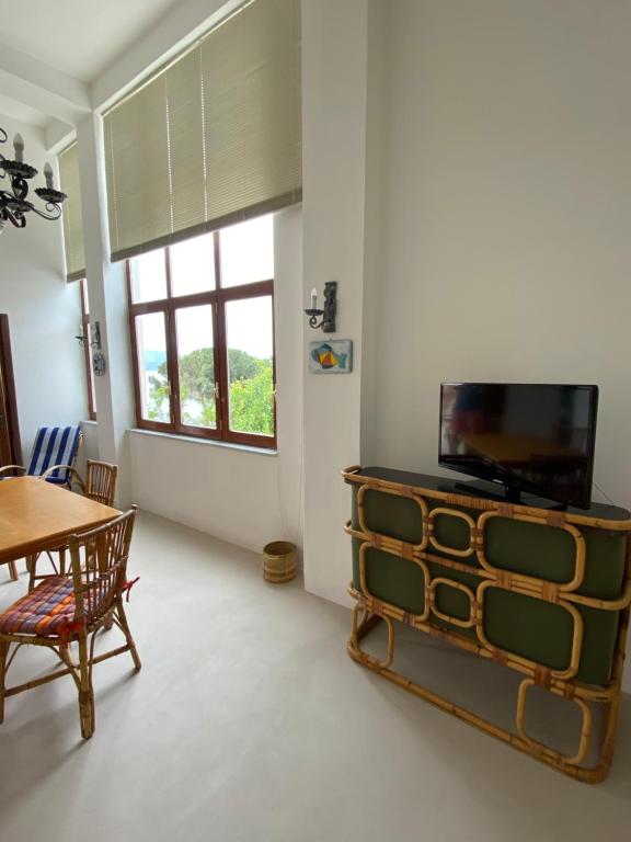 sala de estar con mesa y TV en Casa dell’Arco, en Santa Marina Salina