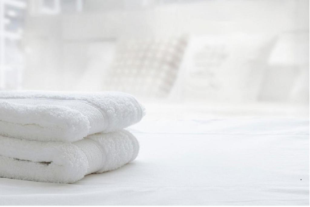 a stack of white towels sitting on a table at UIM Mediterraneo ATICO Poeta 7 Wifi in Puerto de Sagunto