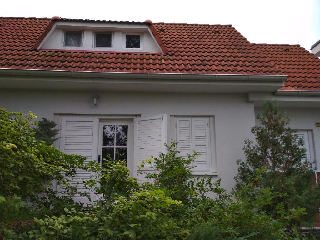 ein weißes Haus mit rotem Dach in der Unterkunft Dovolenkový dom priamo na brehu in Dunajská Streda