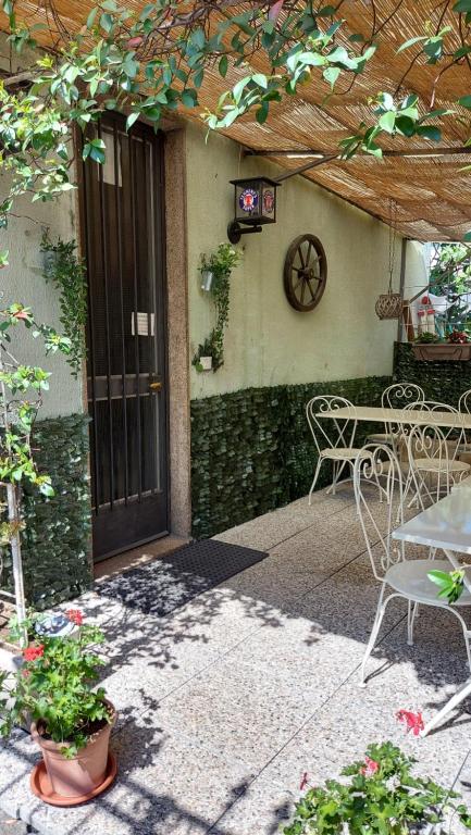 Une porte ouverte s'ouvre sur une terrasse avec une table et des chaises. dans l'établissement Locanda La Tana Del Luppolo, à Valmadrera