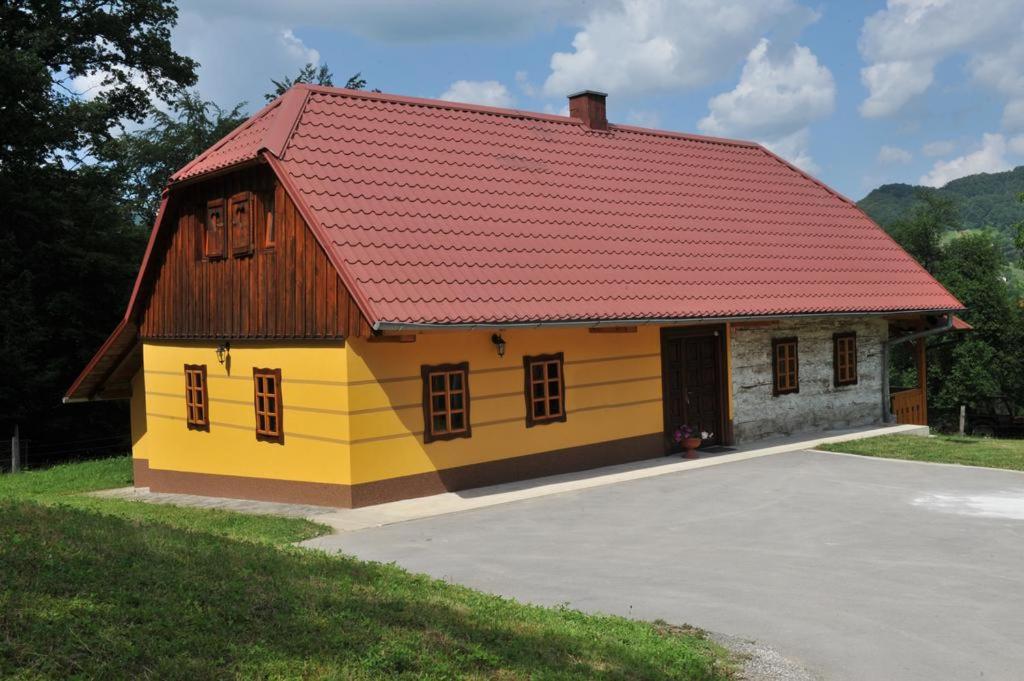 a small yellow and red house with a red roof at Turistična kmetija Kunstek in Rogatec