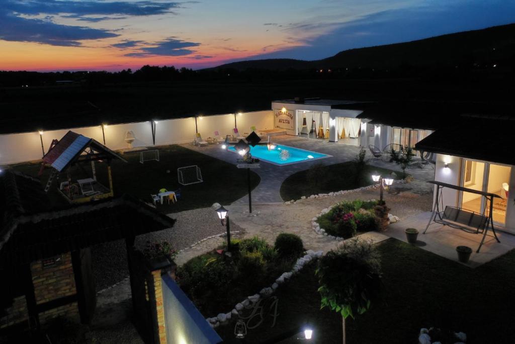 an aerial view of a house with a swimming pool at night at Family estate Hadžalova avlija in Bihać