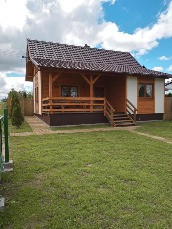 una gran casa de madera con un patio de césped en Domek letniskowy Nad Stawem, en Lipusz
